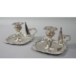 A pair of Victorian style silver plated chamber sticks with conical shaped snuffers,