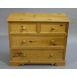 A reproduction pine chest of two short and two long panelled drawers, bracket feet,