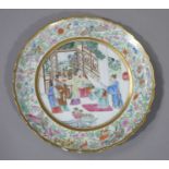 A 19th century Chinese famille verte shaped circular plate the centre painted with figures in a