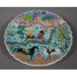 A Turkish shaped circular pottery dish painted with a pair of warriors and horses in an extensive