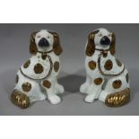 A pair of Staffordshire spaniels with copper lustre decoration, black snouts and yellow eyes,