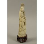 A 19th century carved ivory figure of Guanyin holding a tasselled satchel and a flower spray 16.