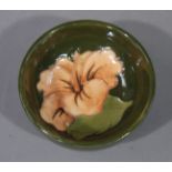 A Moorcroft lily pattern bowl, slip trail decorated on an olive green ground, 8.