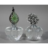 Two cut and facetted glass scent bottles with floral stoppers, 9.