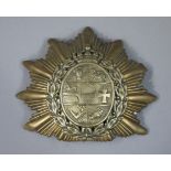 A brass helmet badge,