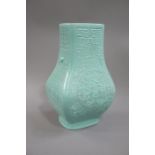 A reproduction Chinese celadon glazed vase the flattened baluster body moulded overall with