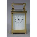 A reproduction brass cased carriage clock with swing handle,