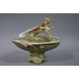 A Royal Dux basket moulded with a young boy resting on a branch his right leg outstretched tickling