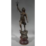 A reproduction bronze effect female figure Chasseresse standing on a rocky outcrop holding a