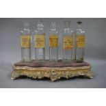 A set of five clear glass pharmacy bottles, slab sided each with a label penned with ink,