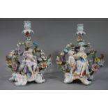 A pair of continental porcelain floral encrusted figural candlesticks one with a female figure with