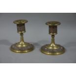 A pair of Arts and Crafts brass and copper candlesticks having beaded scones above a Celtic style