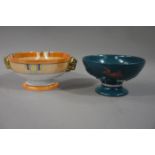 A Noritake orange lustre pedestal bowl with gilded rams mask handles;