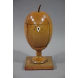 A reproduction fruitwood tea caddy in the form of a melon of ovoid outline on a turned socle and