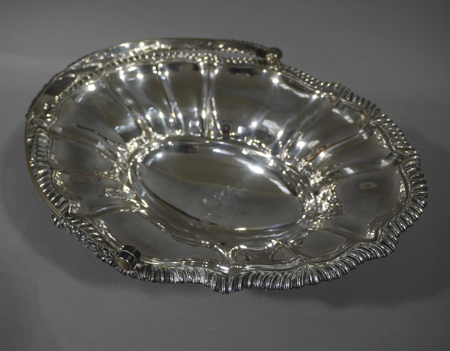 A Victorian Sheffield plate cake basket with reeded acanthus wrapped handle the lobed oval panelled