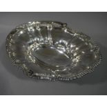 A Victorian Sheffield plate cake basket with reeded acanthus wrapped handle the lobed oval panelled