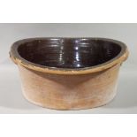 Large terracotta bowl, saltglazed to the interior and with twin cup handles,