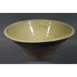 A large terracotta pancheon, cream glazed to the interior,