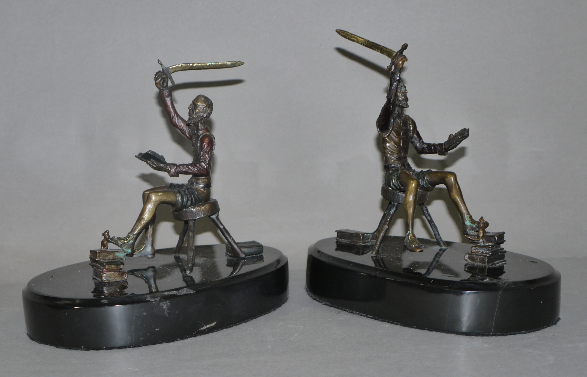 A pair of bronze sculptures of seated figures each reading a book in their left hand raising a - Image 3 of 3