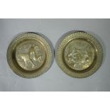 A pair of Arts and Crafts brass dishes one embossed to the centre with a lion rampant on matted