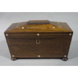 A post Regency rosewood veneered sarcophagus shaped tea caddy outlined throughout with mother of