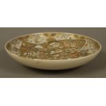 A Japanese eathernware cabinet dish, Meiji period (1868-1912), painted with circular,