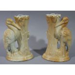 A pair of brown glazed moulded spill vases in the forms of cranes and bull rushes,