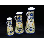 A Graduated Set Of Three Pottery Milk Jugs With Floral Decoration In The Macintyre Style