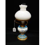 A Circular Based Gilt Metal & Pottery Oil Lamp With Milk Glass Shade