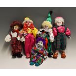 Porcelain Clown Dolls one a wind-up music playing doll, the others dressed in various outfits with