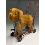 Triang push/ride along dog sitting on a steel frame with rubber wheels, measures 60x63cm approx. and
