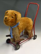 Triang push/ride along dog sitting on a steel frame with rubber wheels, measures 60x63cm approx. and