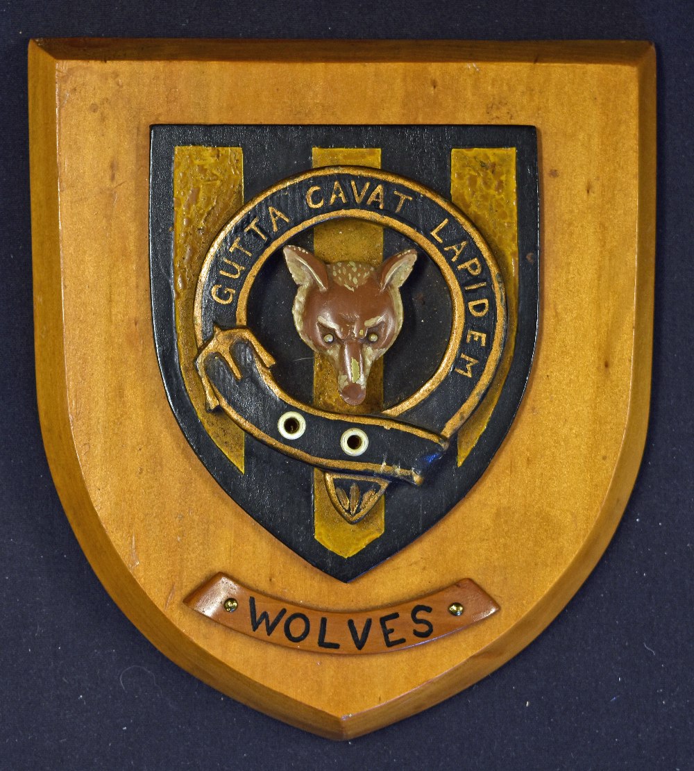 A Wolves (circa 1920's style) polished hardwood plaque in the form of a shield depicting a wolf