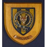 A Wolves (circa 1920's style) polished hardwood plaque in the form of a shield depicting a wolf