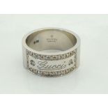 GUCCI EIGHTEEN CARAT WHITE GOLD AND DIAMOND RING the Gucci engraved panel in diamond surround,