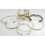 SELECTION OF SEVEN SILVER BANGLES of various sizes and designs (7)
