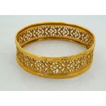 UNMARKED HIGH CARAT GOLD BANGLE with profuse pierced decoration overall, approximately 15.