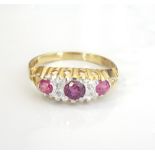 RUBY AND DIAMOND DRESS RING the three rubies separated by small diamonds, on nine carat gold shank,