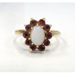 OPAL AND RUBY CLUSTER RING the central oval cabochon opal in ten diamond surround,