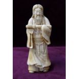 19th CENTURY JAPANESE CARVED IVORY OKIMONO depicting a Samurai warrior holding his sword and with a