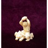 19th CENTURY JAPANESE CARVED IVORY NETSUKE in the form of a man seated astride a dog and clasping a
