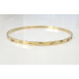 NINE CARAT GOLD BANGLE with engraved decoration, approximately 3.