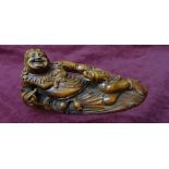 CHINESE BOXWOOD CARVED FIGURE OF A RECLINING BUDDHA the laughing Buddha leaning on a gourd and