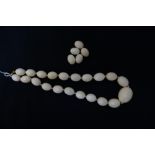 LARGE GRADUATED IVORY BEAD NECKLACE with twenty one oval beads,