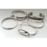 SEVEN SILVER BANGLES of various sizes and designs (7)