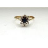 SAPPHIRE AND DIAMOND CLUSTER RING the central round cut sapphire in eight diamond surround,