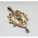 EDWARDIAN AQUAMARINE SET HOLBEIN PENDANT the central oval cut aquamarine in floral and scroll