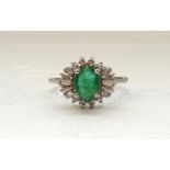 EMERALD AND DIAMOND CLUSTER DRESS RING the central oval cut emerald approximately 1ct,