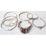 SELECTION OF SEVEN SILVER BANGLES of various sizes and designs,