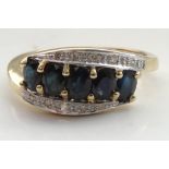 SAPPHIRE AND DIAMOND CLUSTER RING the five oval cut sapphires with diamonds above and below,